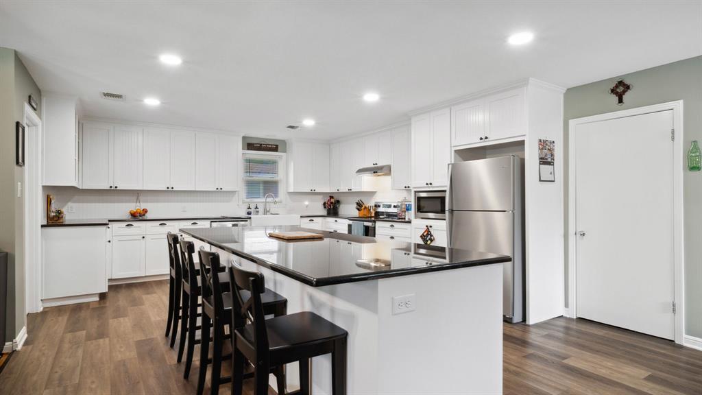 a kitchen with refrigerator and chairs