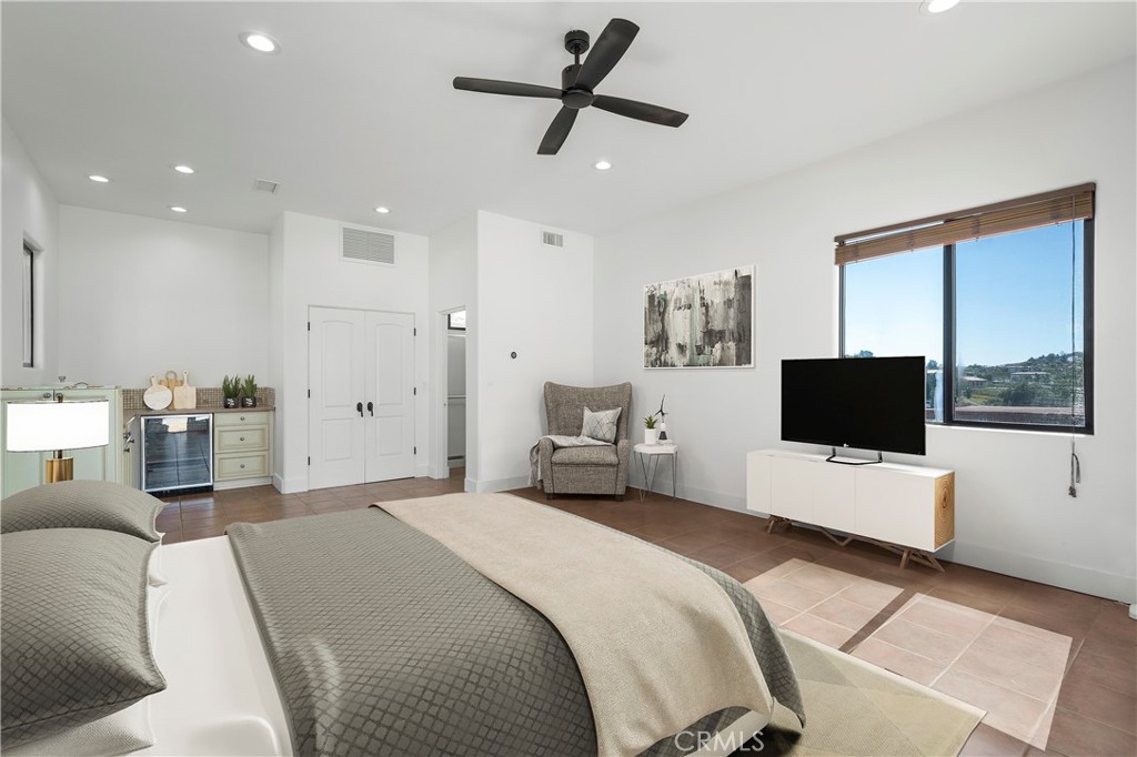 a bedroom with a bed window and a flat screen tv