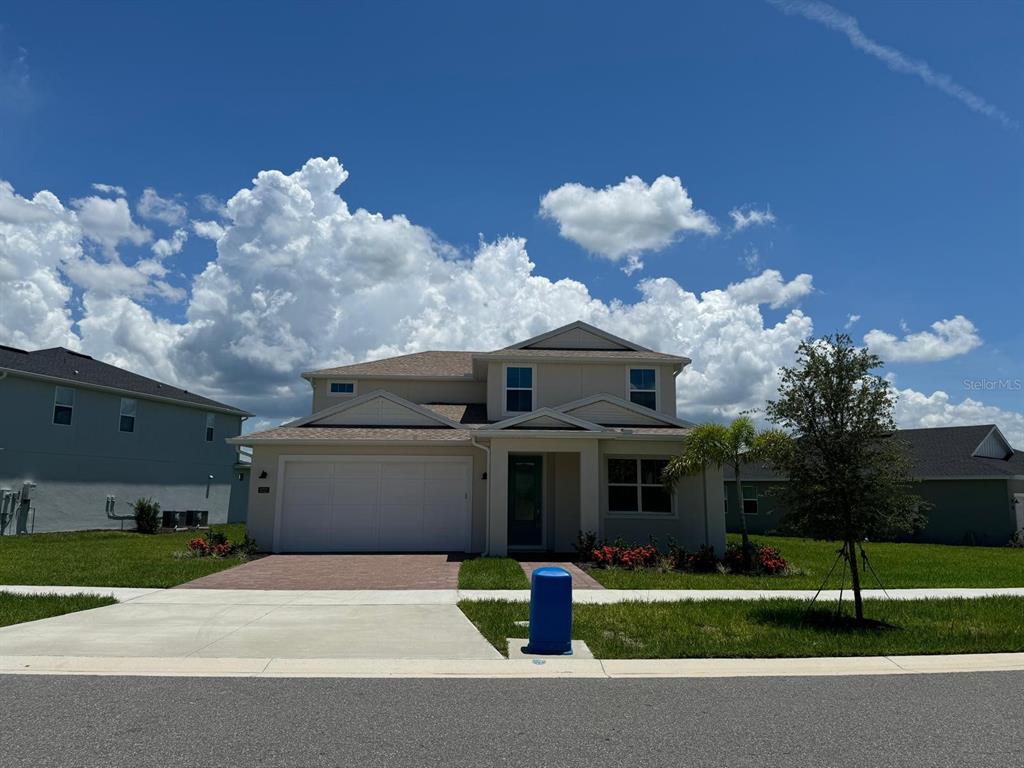 a front view of a house with a yard and a garage