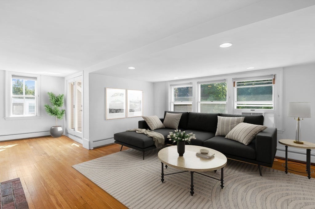 a living room with furniture and a wooden floor