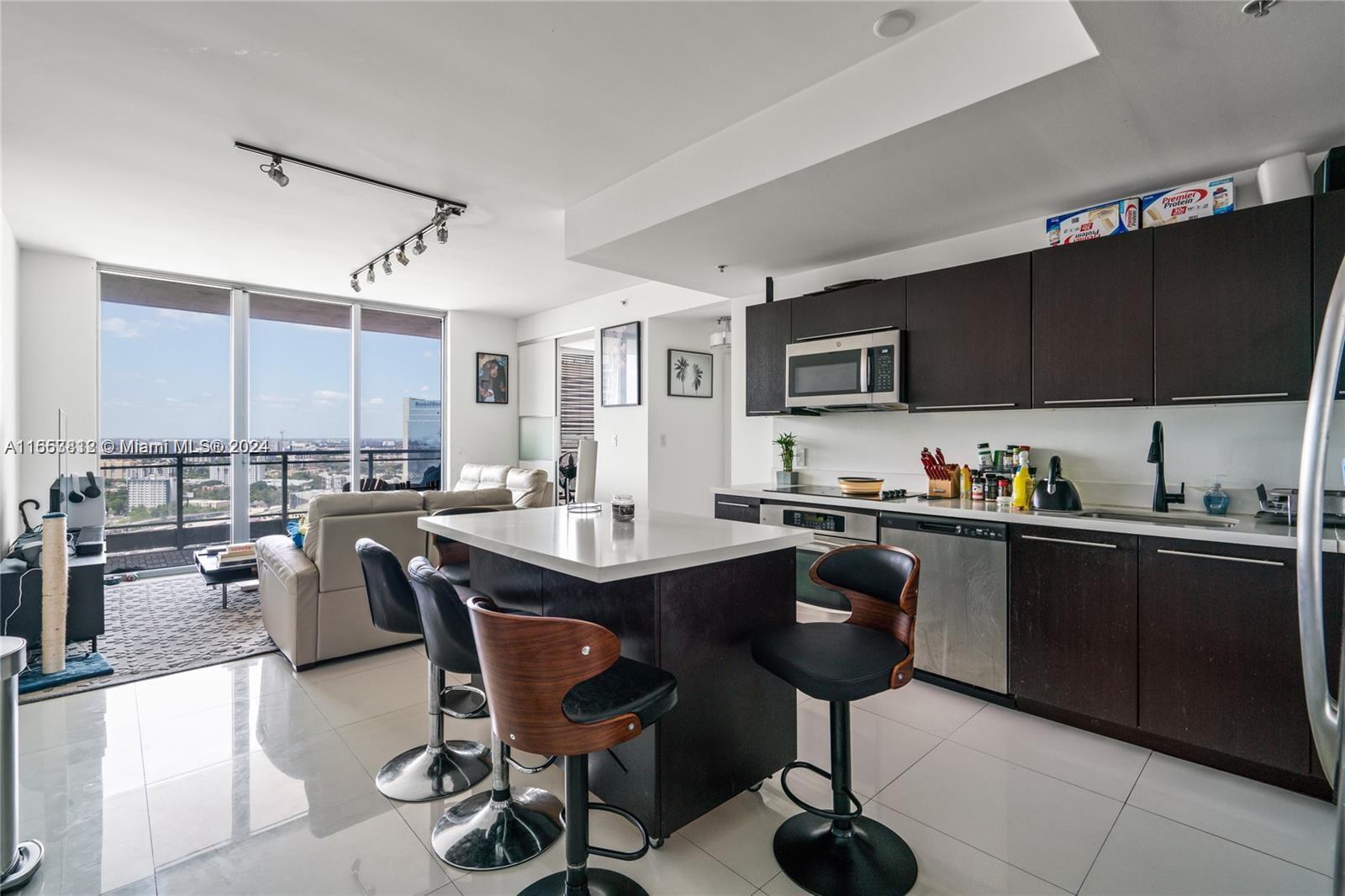 a kitchen with granite countertop a sink counter top space appliances and cabinets