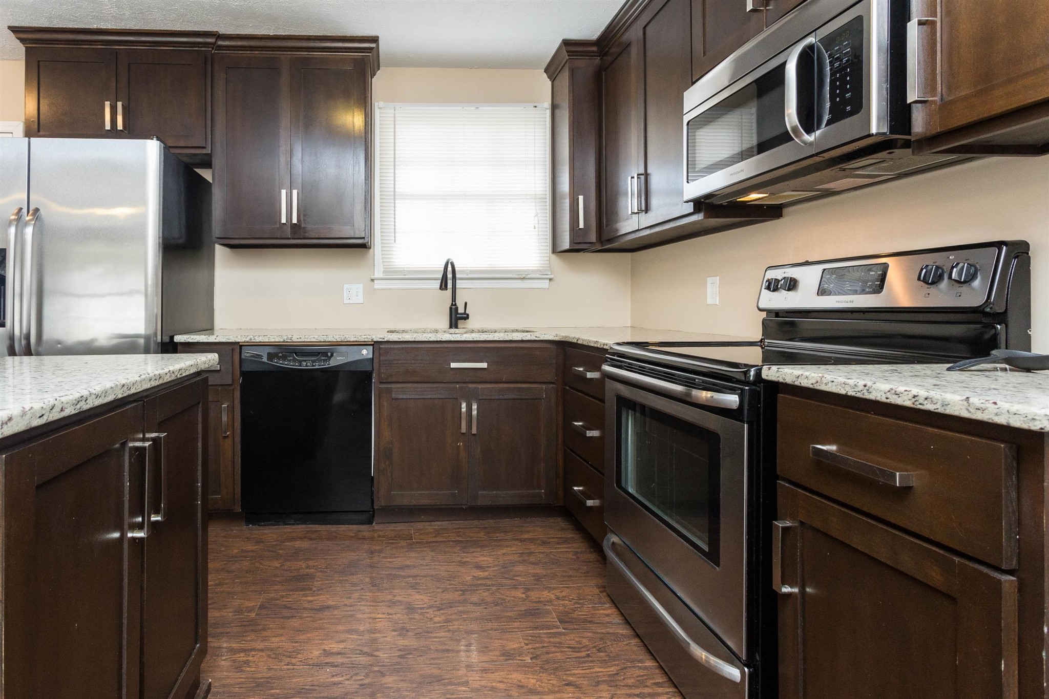 a kitchen with stainless steel appliances granite countertop a sink stove and microwave