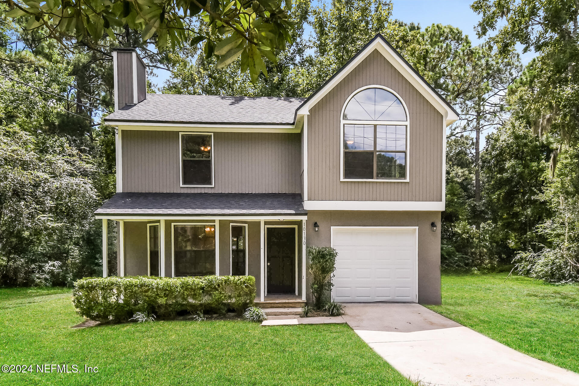 a front view of a house with a garden and yard