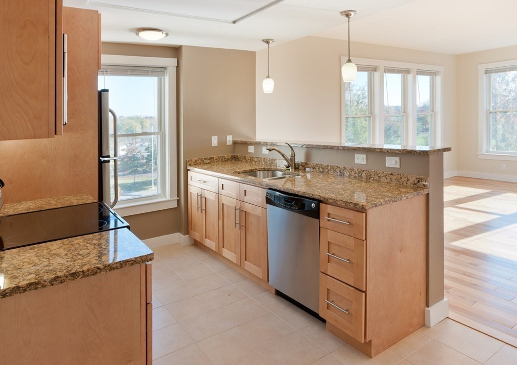 a kitchen with stainless steel appliances granite countertop a sink stove and a refrigerator