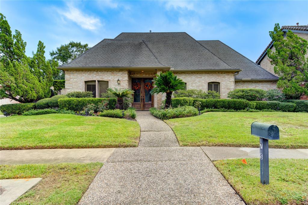 a front view of a house with a yard and potted plants