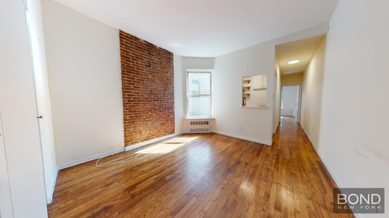 a view of a hallway with wooden floor and closet