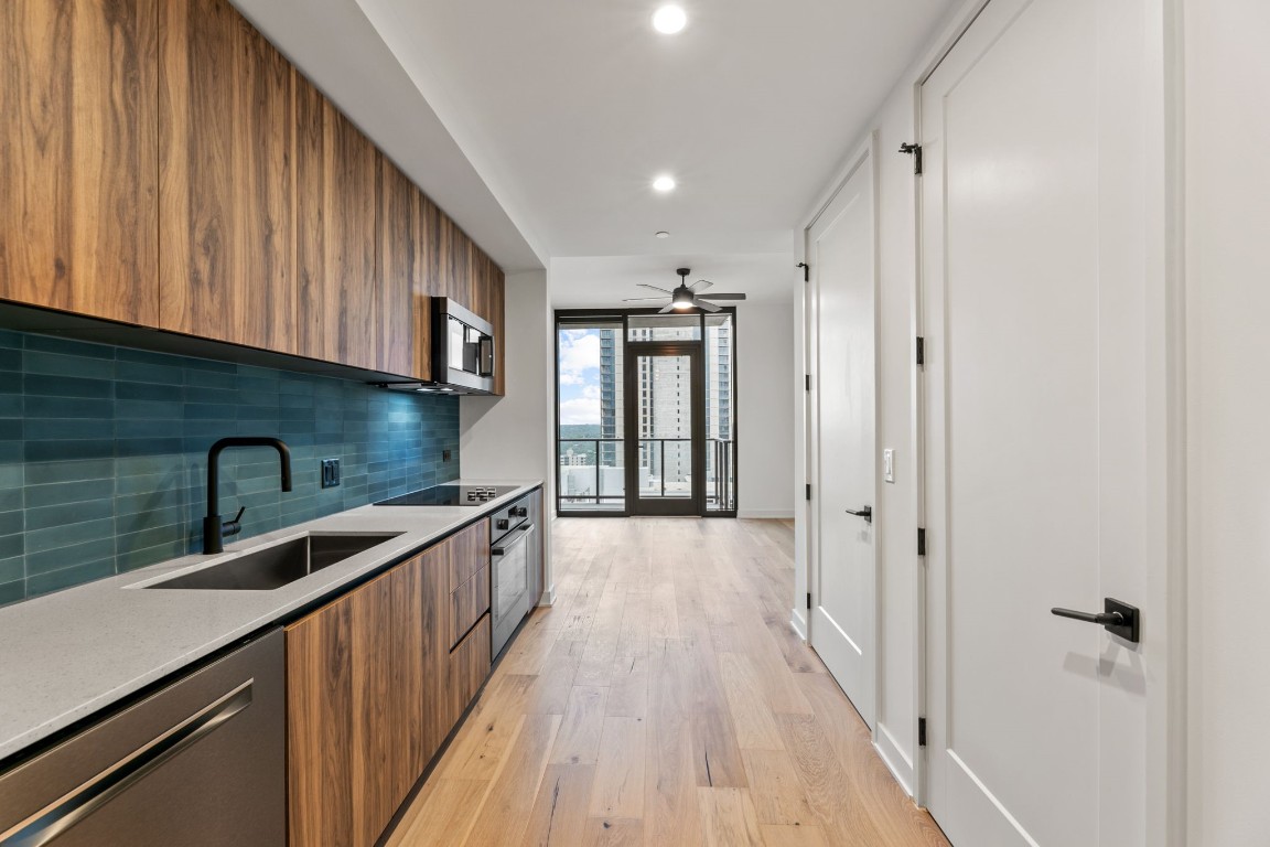 a kitchen with stainless steel appliances granite countertop a sink and wooden cabinets