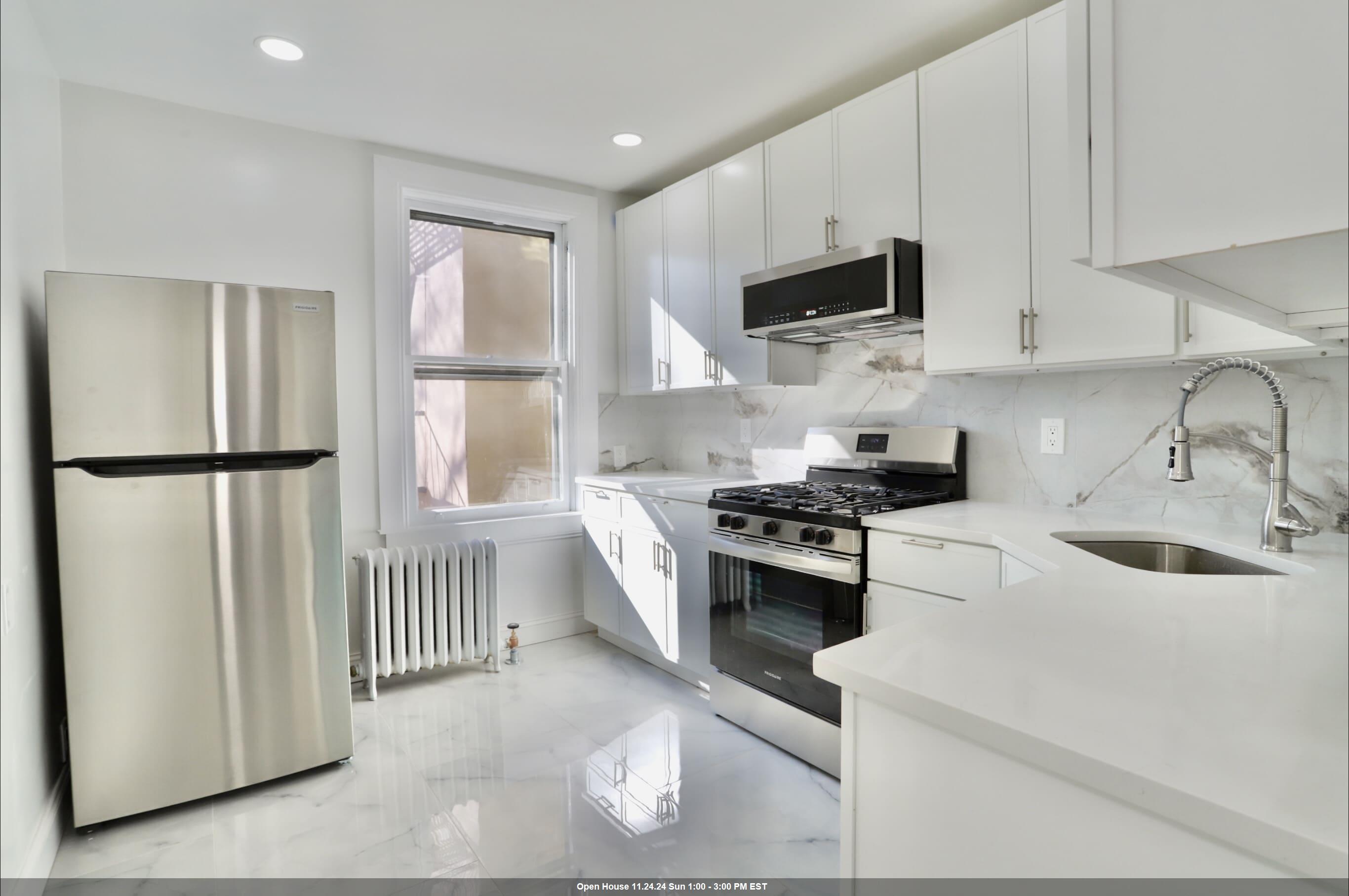 a kitchen with stainless steel appliances granite countertop white cabinets a stove top oven a sink and dishwasher