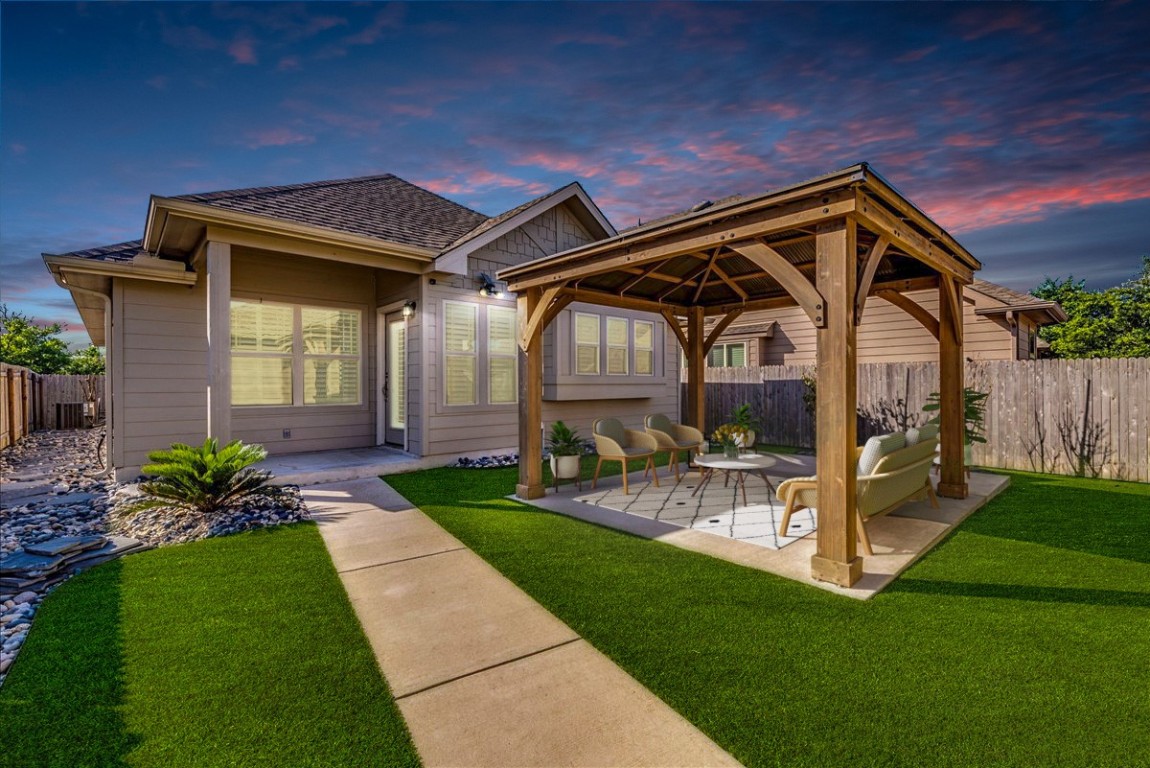 a view of a house with a small yard and wooden fence