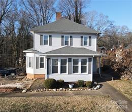 a front view of a house with a yard covered with snow