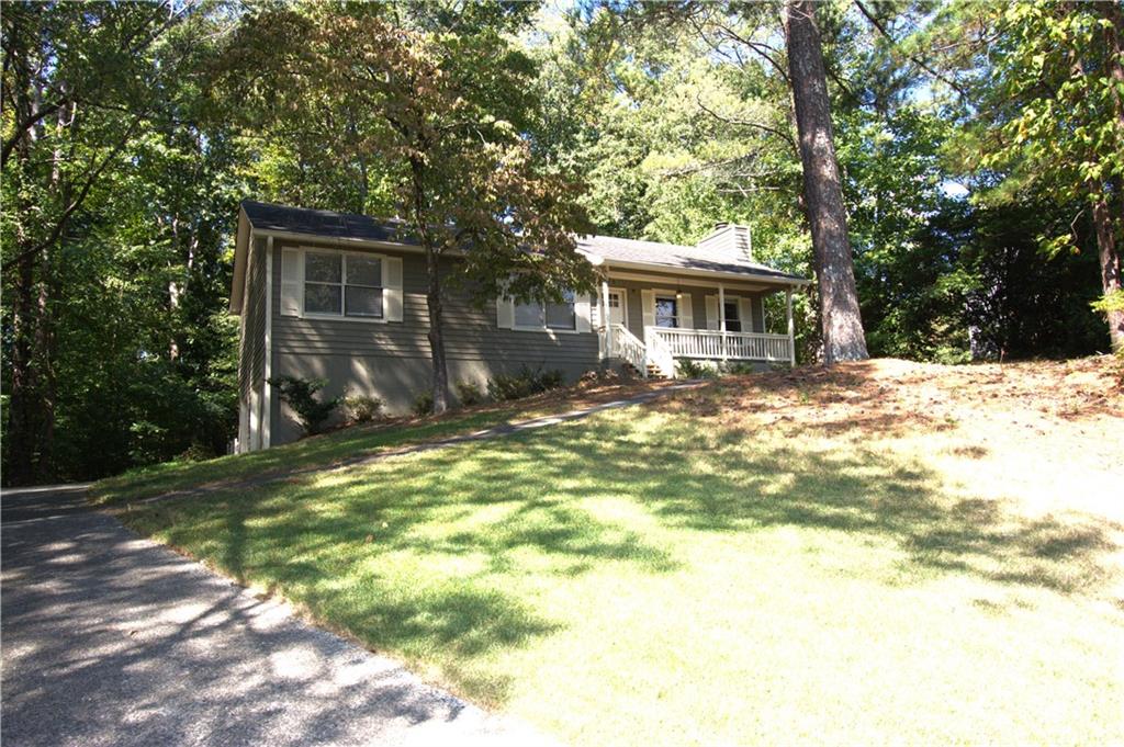 a view of a yard in front of a house with large trees