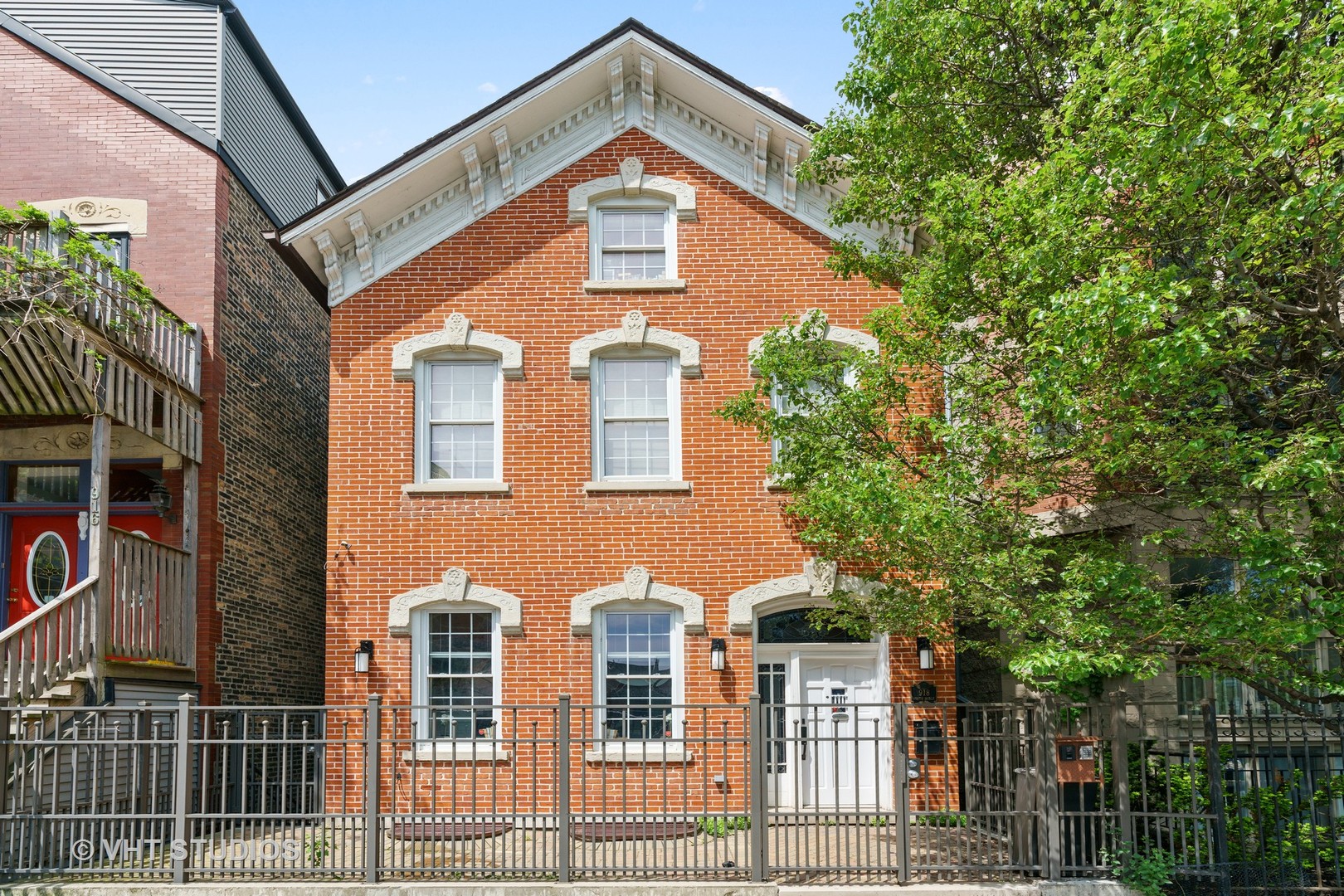 a front view of a house with a tree