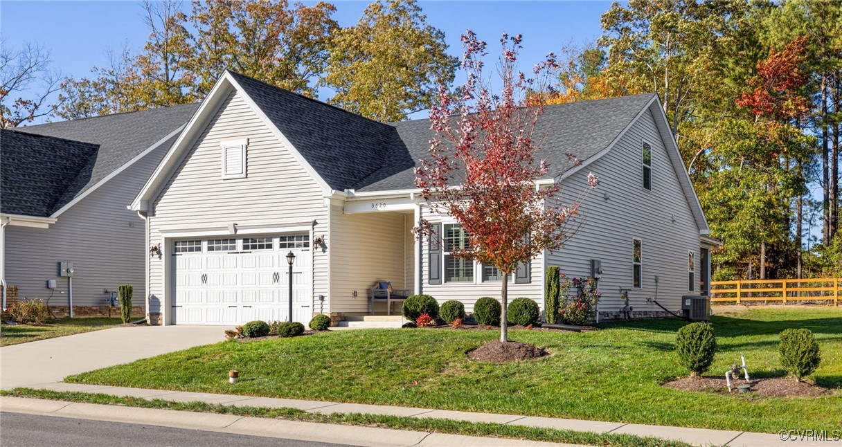 View of front of house with central AC, a garage,