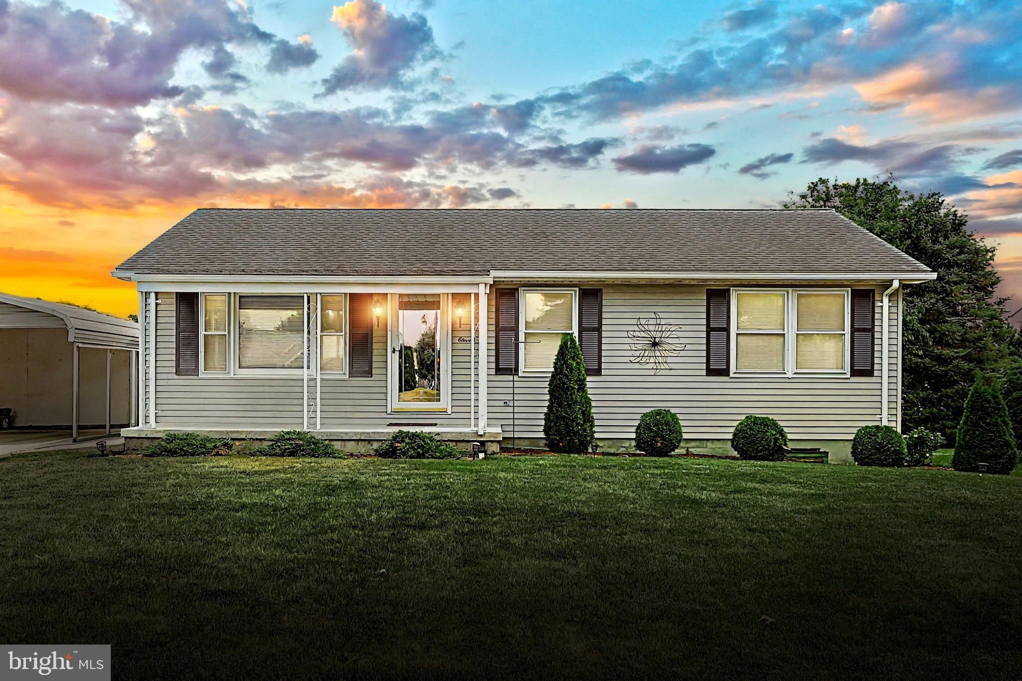 a view of a white house with yard and plants