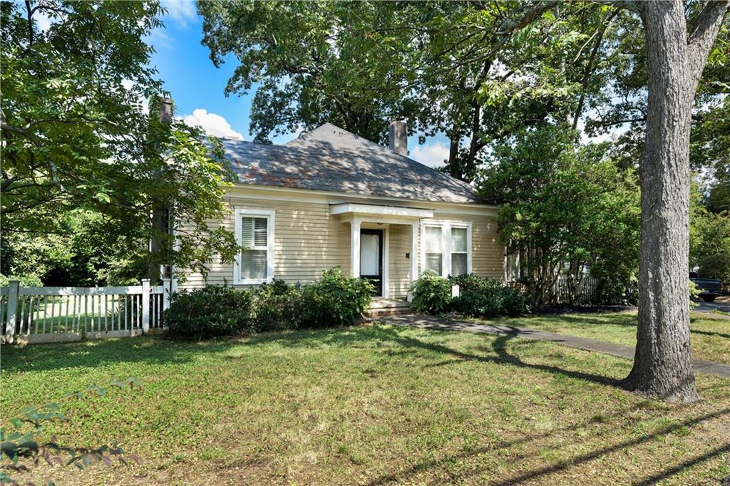 a view of a house with backyard and a tree