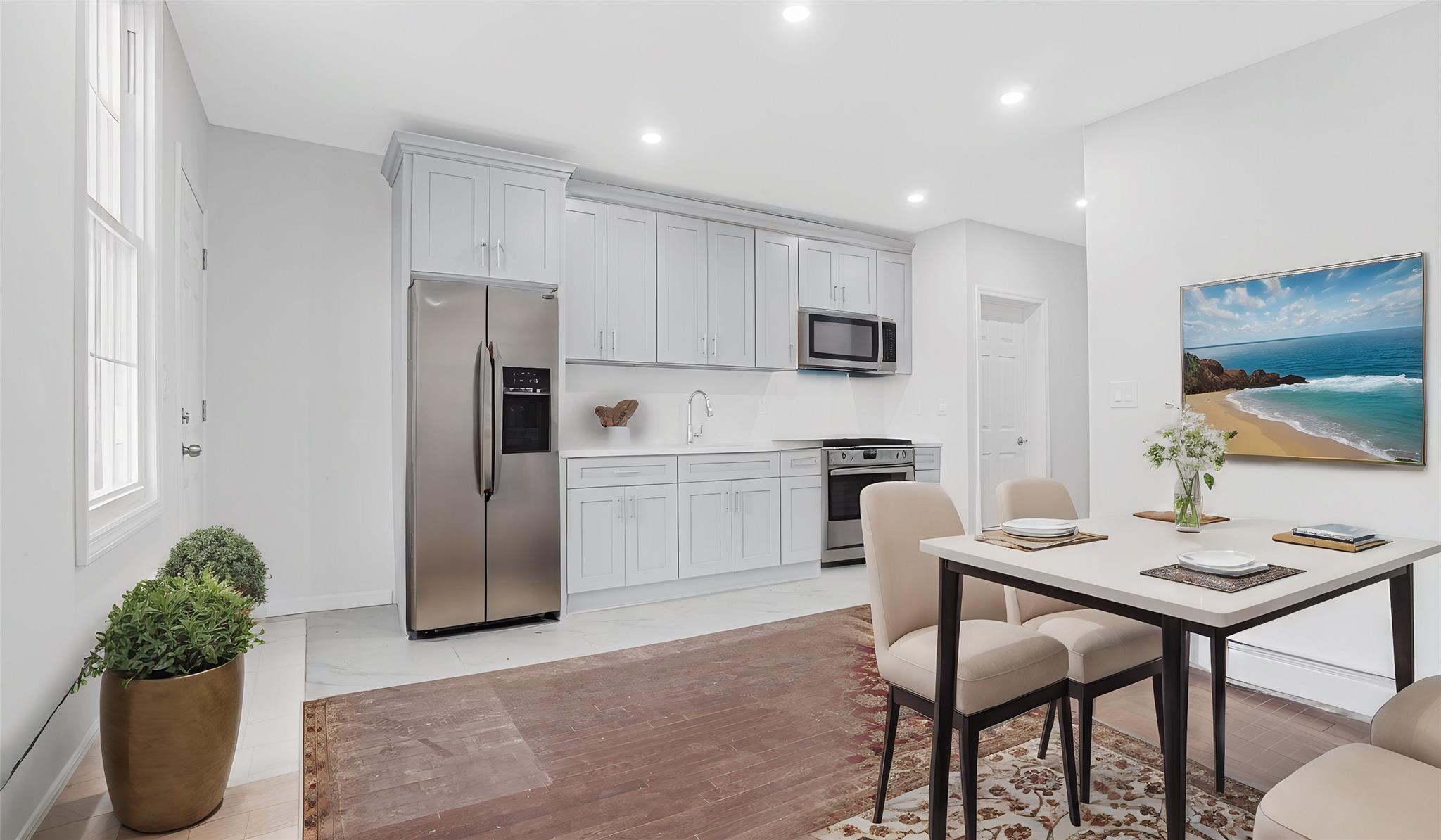 Kitchen with gray cabinets, sink, light hardwood / wood-style floors, and appliances with stainless steel finishes