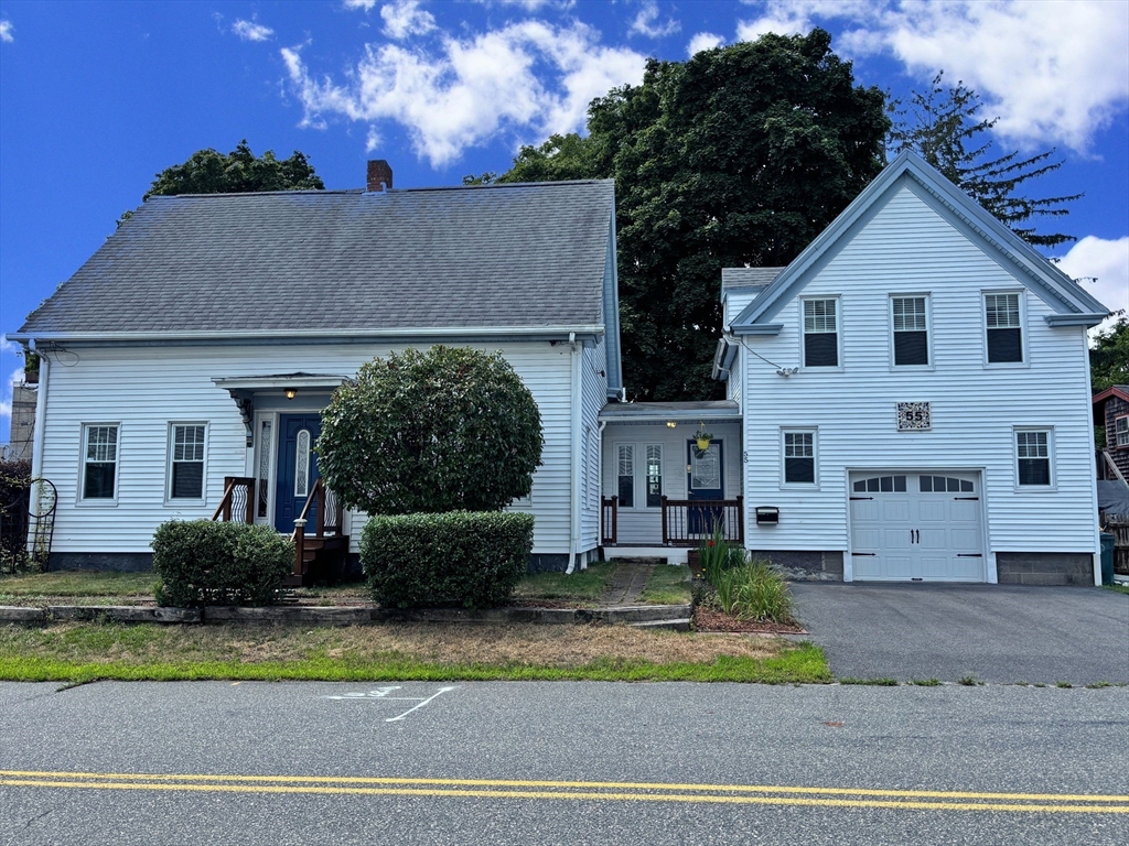 a view of a white house with large windows and a small yard