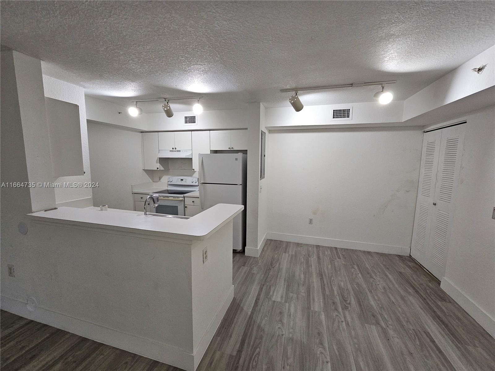 a kitchen with kitchen island a sink appliances and cabinets