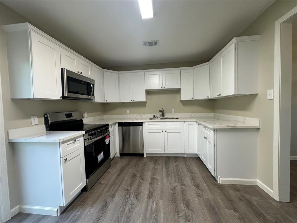 a kitchen with a white stove top oven sink and cabinets