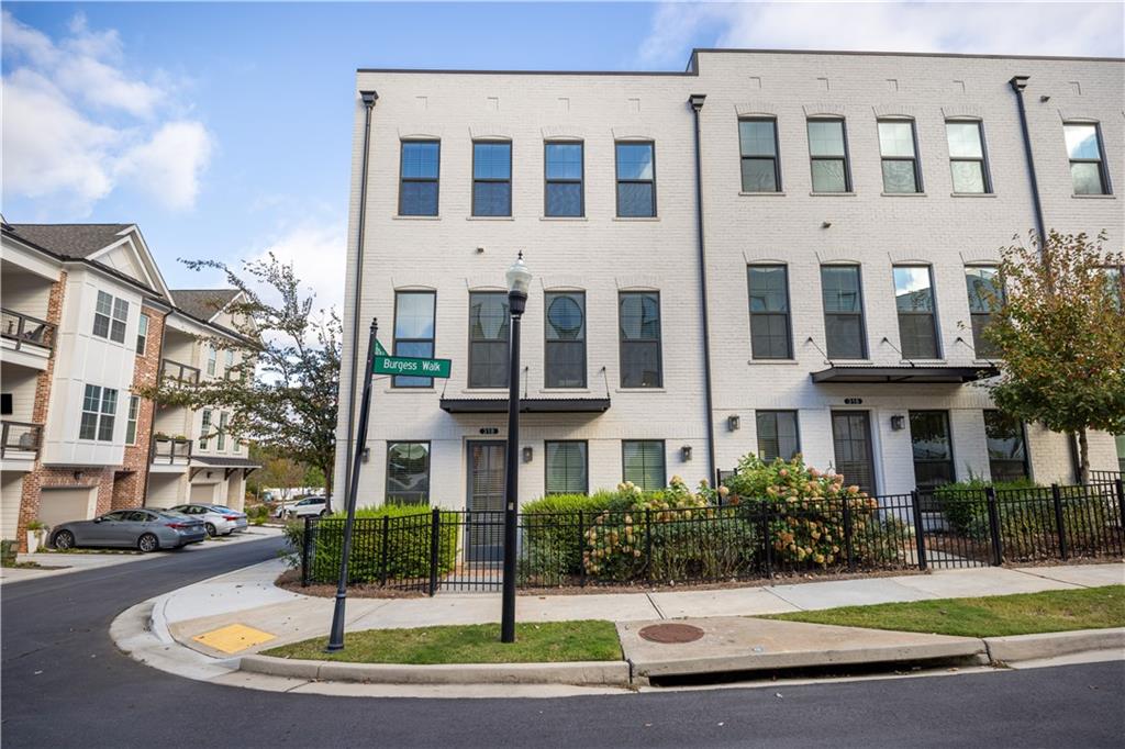 a front view of a multi story residential apartment building with yard and traffic signal