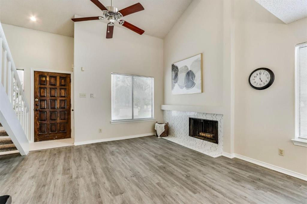 a view of an empty room with a fireplace and a window