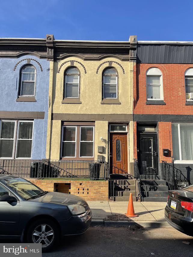 a front view of a house with cars parked