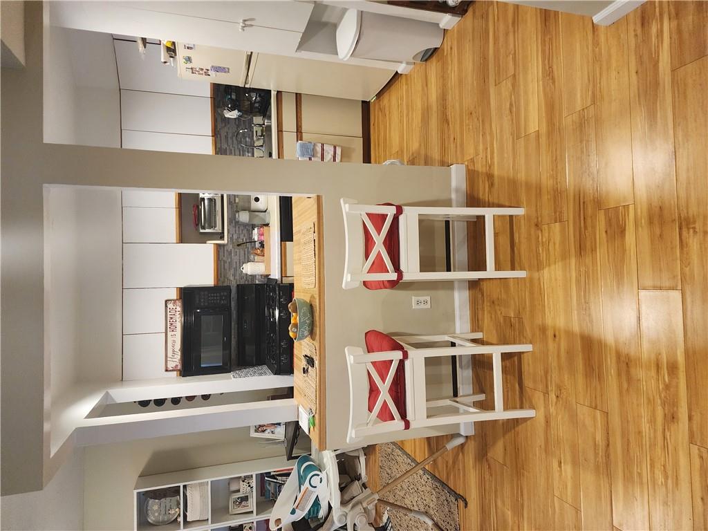 Kitchen featuring fridge, white range, light wood-type flooring, and decorative backsplash