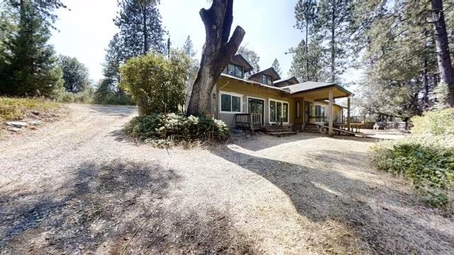 a front view of house with yard outdoor seating and trees