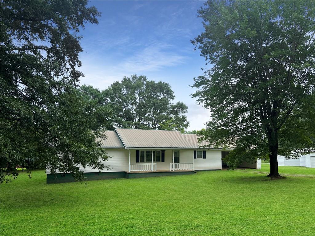 a view of a big house with a big yard and large trees