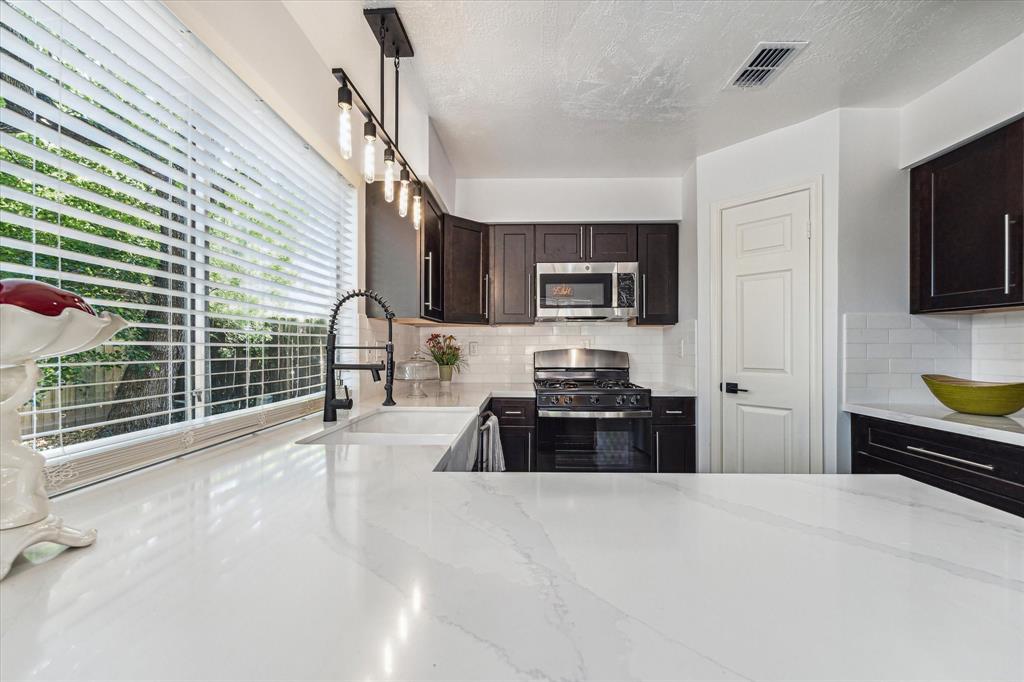 a kitchen with sink a stove and cabinets