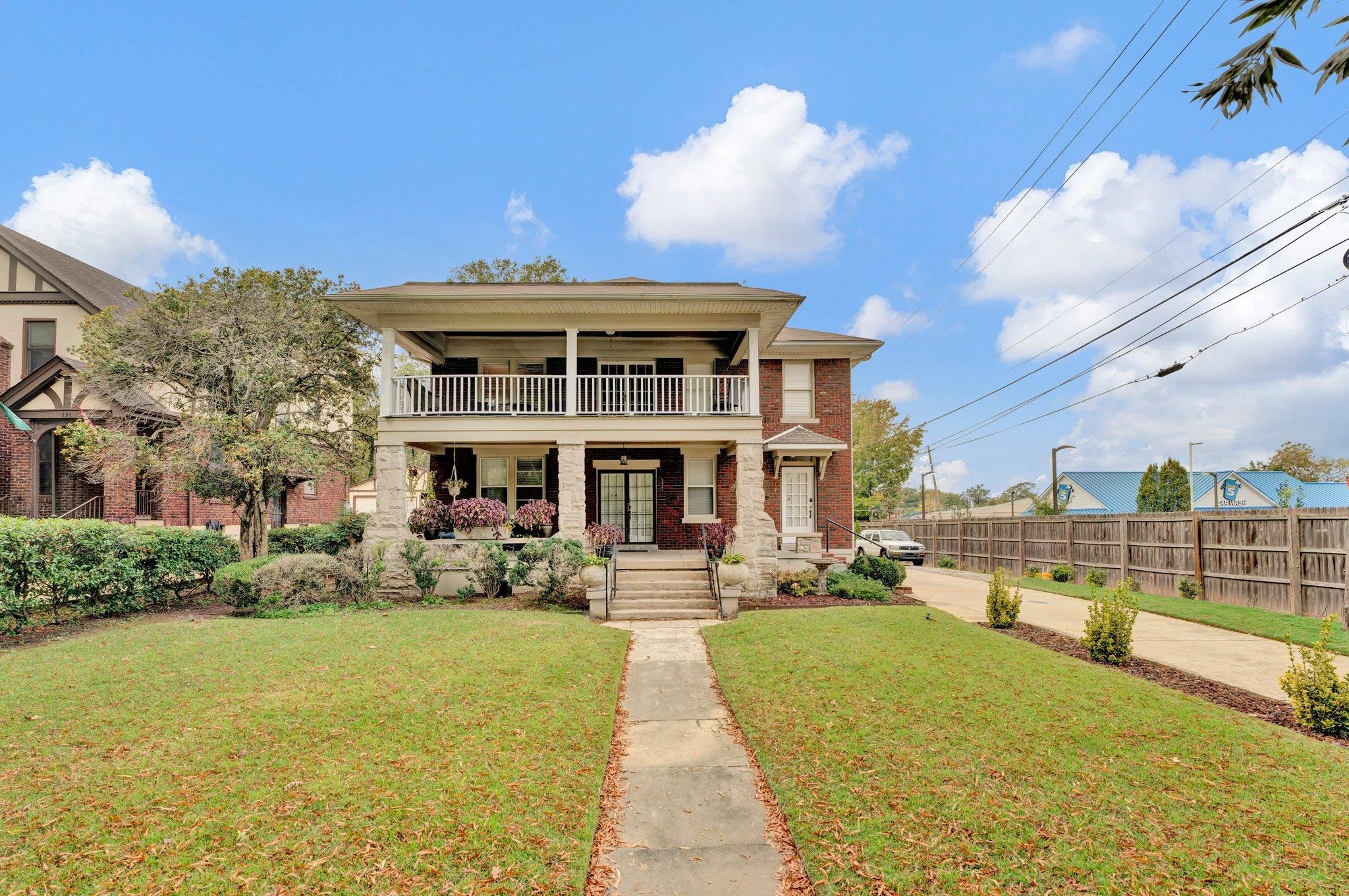 View of front facade featuring a front yard and a balcony