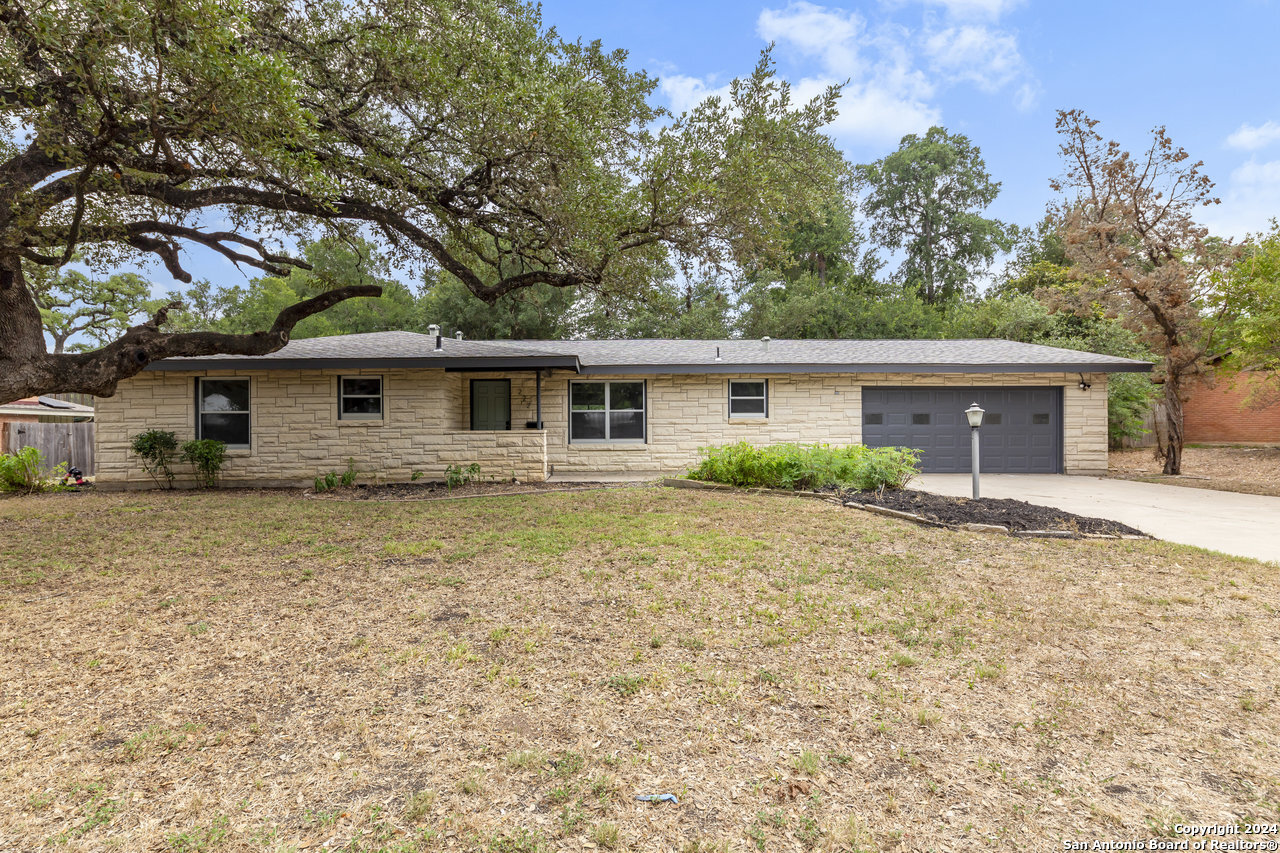 a front view of house with yard and trees around