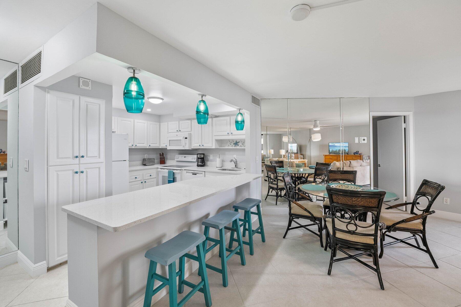 a kitchen with kitchen island a dining table and chairs