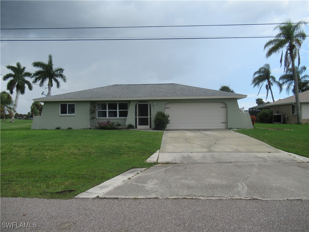 a front view of a house with a garden and palm trees