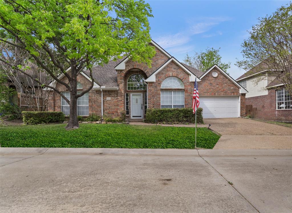 front view of a house with a yard and an trees