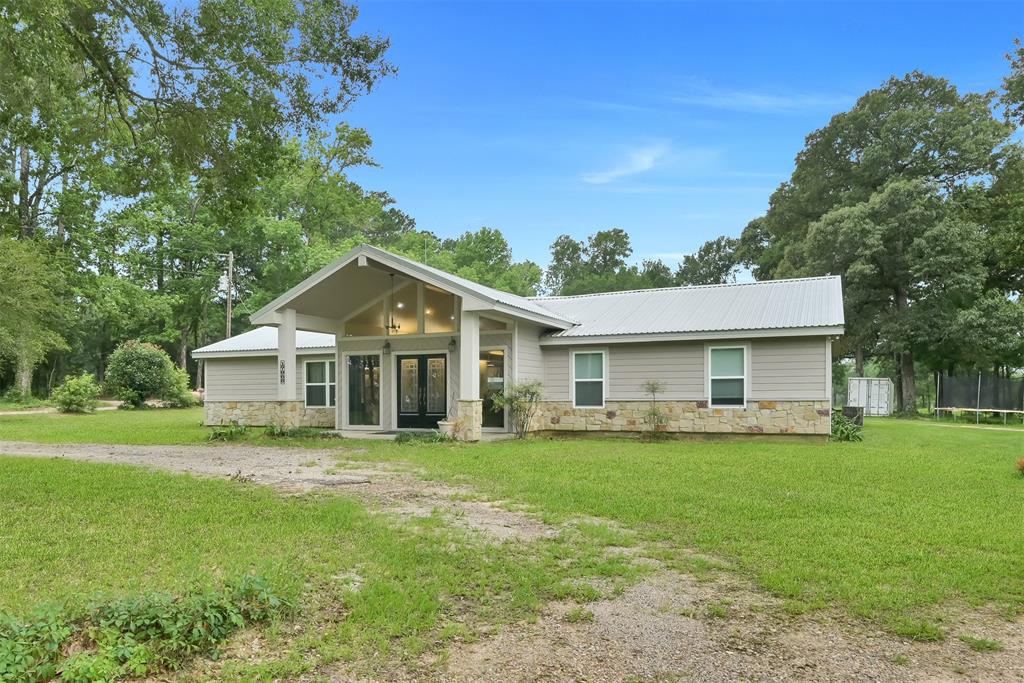 a front view of a house with a yard and trees