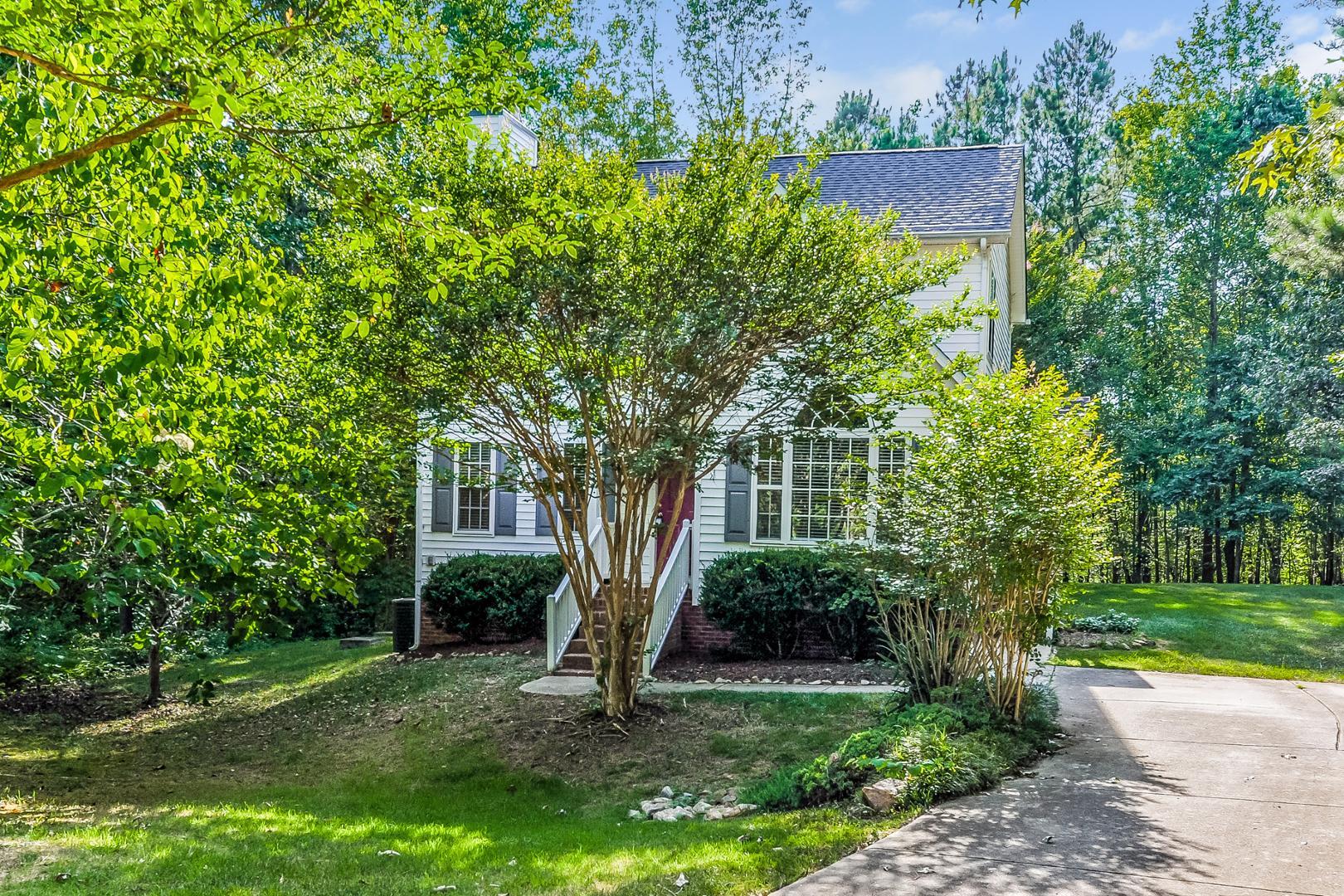 a view of a house with a tree and a garden