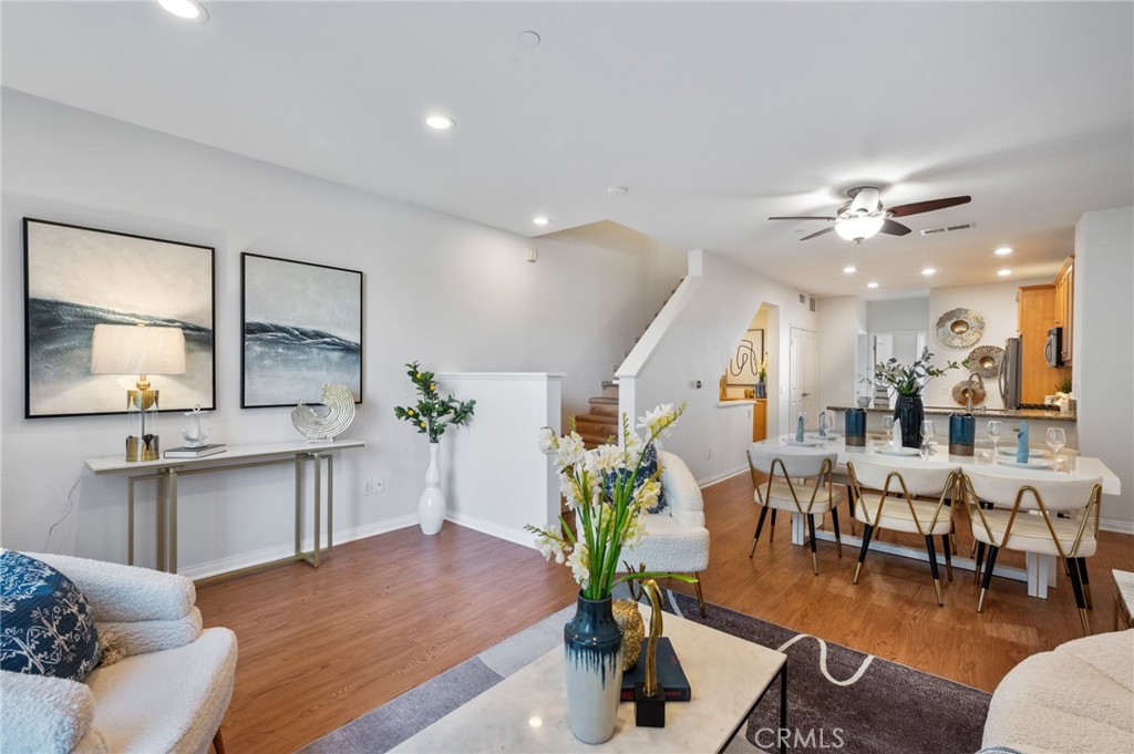 a living room with furniture potted plant and kitchen view