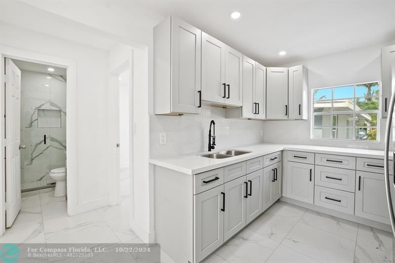 a kitchen with white cabinets and white appliances