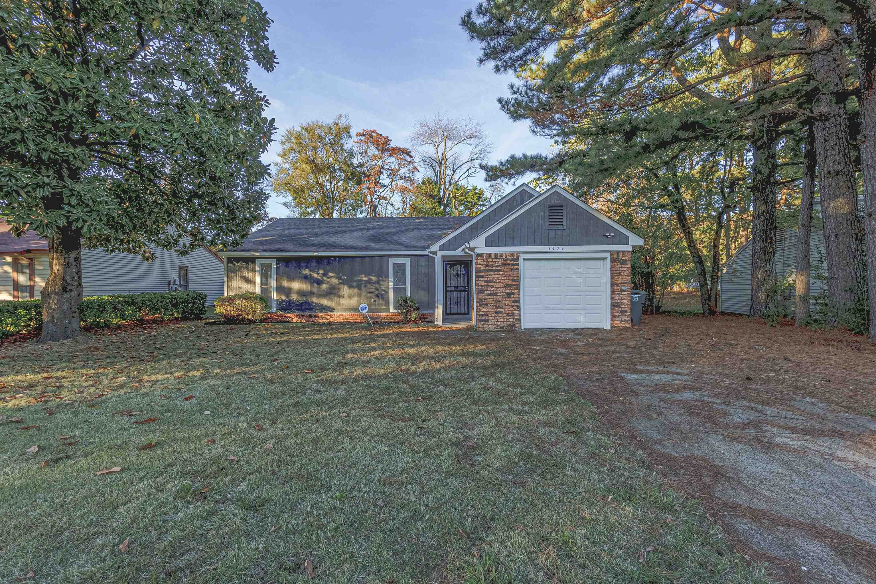 Ranch-style house featuring a garage and a front lawn