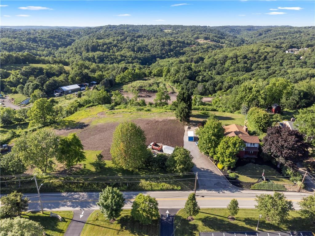 an aerial view of residential houses with outdoor space and trees