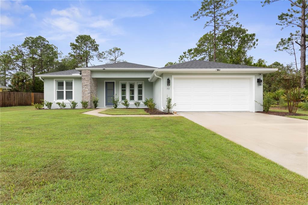 a front view of a house with a yard and trees