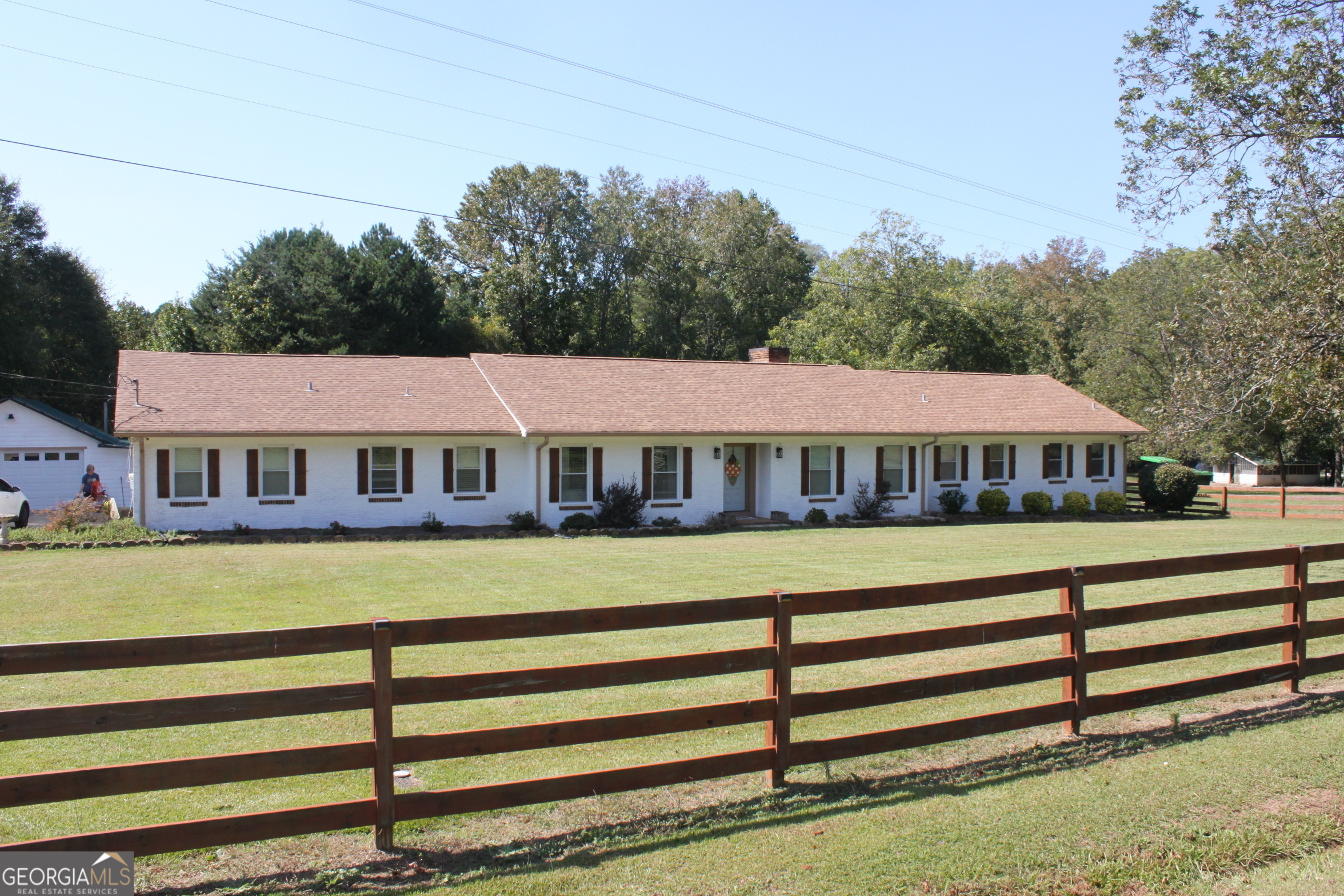 a view of a house with a big yard and large trees