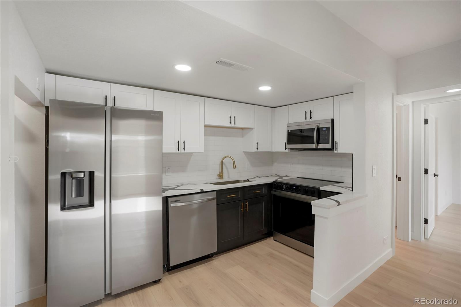 a kitchen with cabinets and stainless steel appliances