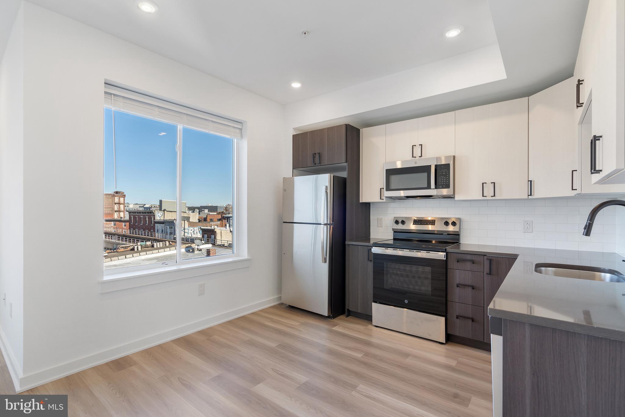 a kitchen with stainless steel appliances granite countertop a refrigerator stove top oven and sink