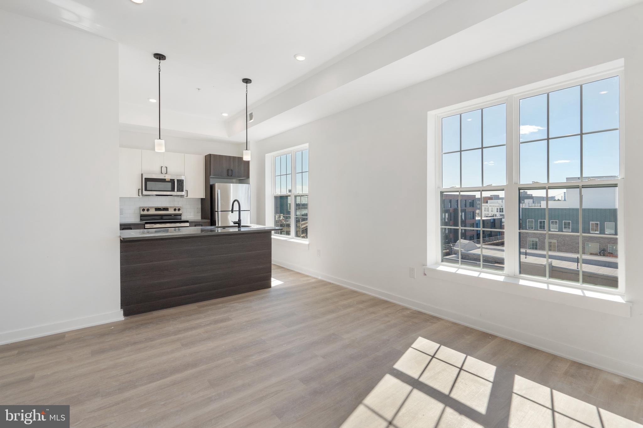 a kitchen with stainless steel appliances granite countertop a stove a sink and a large window