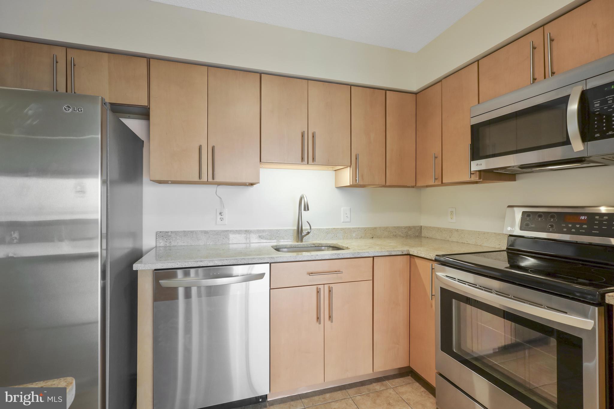 a kitchen with appliances a sink and cabinets