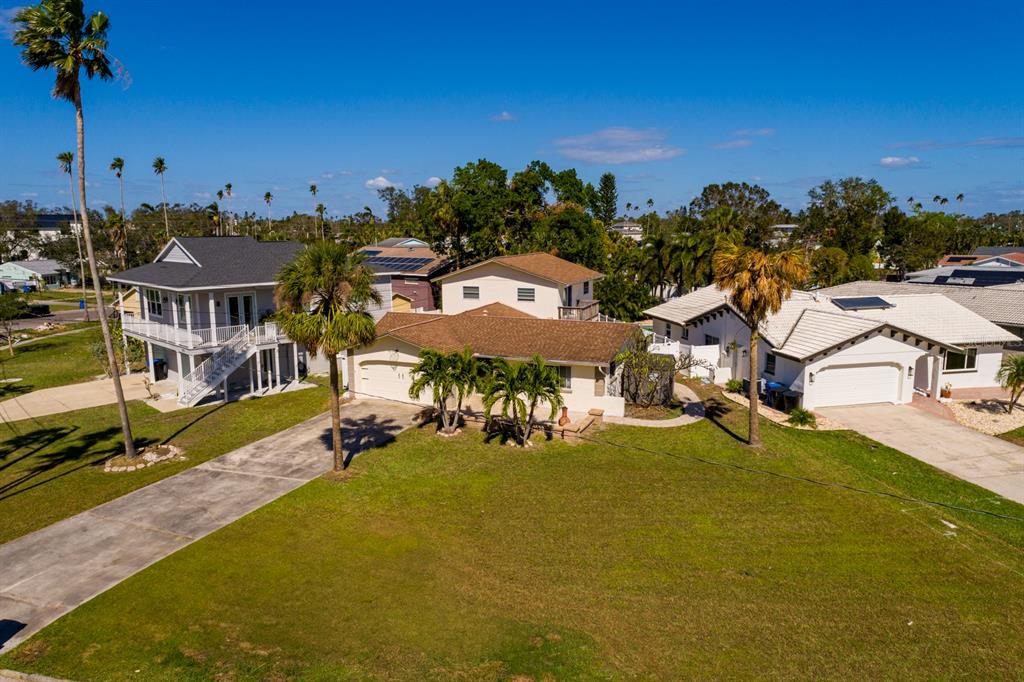 an aerial view of a house with swimming pool and large trees