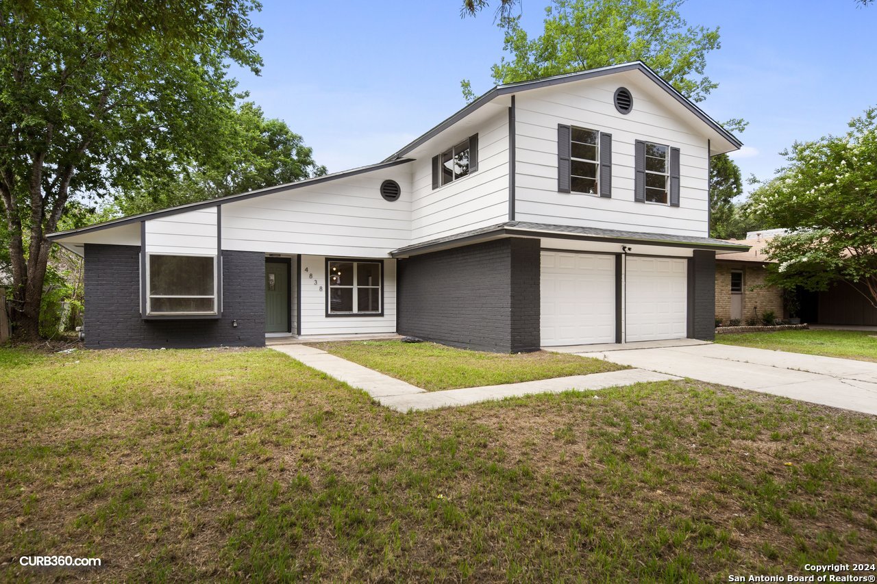 a front view of a house with a yard and garage