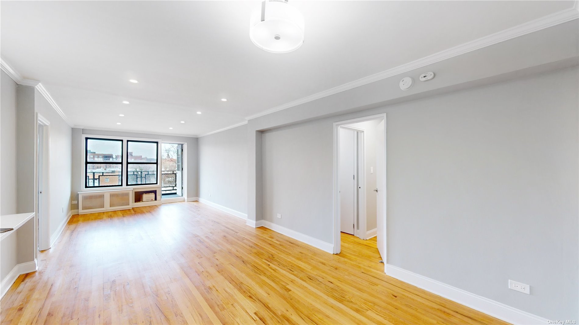 a view of empty room with wooden floor and window